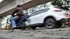 Kendaraan melintas di jalan rusak yang berada di kawasan Kelapa Gading, Jakarta, Rabu (5/9). Permasalahan jalan rusak dan berlubang di kawasan tersebut hingga kini belum juga teratasi. (Merdeka.com/Iqbal S. Nugroho)