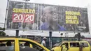 Orang-orang melewati spanduk pemilihan Presiden Felix Tshisekedi menjelang pemilihan presiden, di Kinshasa, Republik Demokratik Kongo, Selasa, 19 Desember 2023. (AP Photo/Mosa'ab Elshamy)