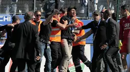 Suporter Bastia diamankan petugas keamanan saat terjadi bentrok dengan pemain Lyon pada laga Ligue 1 Prancis di Armand Cesari stadium, Bastia, (16/4/2017). Laga ini akhirnya dihentikan LFP. (AFP/Pascal Pochard-Casabianca)