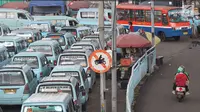 Pengendara sepeda motor melintasi jalur angkutan umum di Terminal Kampung Melayu, Jakarta, Rabu (6/2). Sejumlah pengendara nekat menerobos masuk terminal untuk memotong jalur guna memersingkat waktu tempuh. (Liputan6.com/Immanuel Antonius)