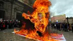 Para pengunjuk rasa membakar patung karakter Presiden AS Donald Trump saat melakukan aksi protes pada peringatan Hari Buruh di Bogota, Kolombia (1/5). Warga Kolombia merayakan Hari Buruh dengan membakan patung Donald Trump. (AP/Fernando Vergara)