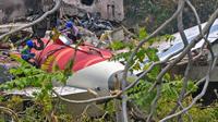 Pekerja yang mengangkat ekor pesawat dari reruntuhan setelah kecelakaan penerbangan Air India 171 pada 12 Juni, terlihat di area permukiman dekat bandara di Ahmedabad pada 14 Juni 2025. (Dok: DIBYANGSHU SARKAR / AFP)