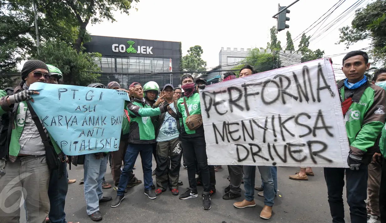 Massa driver Gojek membawa poster berisi tuntutan mereka saat berunjuk rasa di kantor PT Gojek Indonesia, Kemang, Jakarta, Senin (3/10). Driver Gojek itu menuntut agar sistem performa segera dihapus karena menyusahkan mereka. (Liputan6.com/Yoppy Renato)