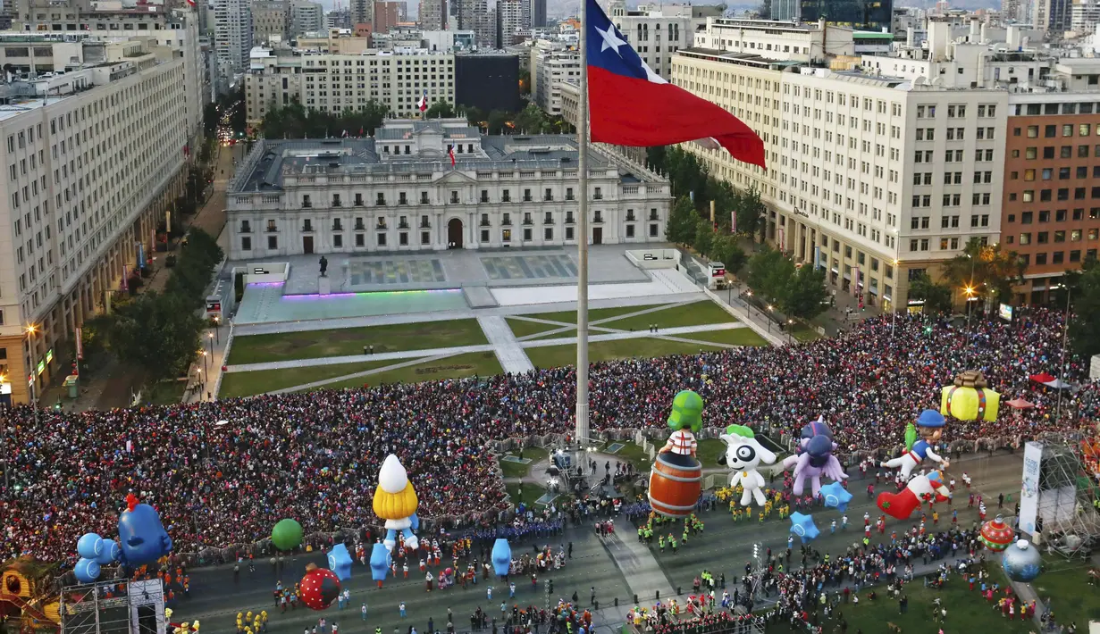 Parade balon karakter kartun meramaikan jalanan kota Santiago di Chile, (13/12). Kegiatan ini untuk menyambut Natal yang akan jatuh sebentar lagi. (REUTERS/Pablo Sanhueza)