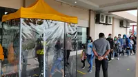 Penumpang di Bandara Sentani Kabupaten Jayapura melewati bilik penyemprot disinfektan yang disediakan Angkasapura I. (Liputan6.com/Bandara Sentani/Katharina Janur)