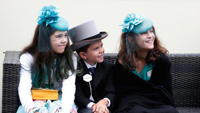 Chase Spranklin (tengah) bersama Aly Oraeno (kiri) dan Olivia Manzanero asal Amerika Serikat mengenakan topi atau fascinator unik saat menghadiri ajang pacuan kuda Royal Ascot di Ascot, Inggris, Selasa (18/6/2019). (AP Photo/Hibah Alastair)