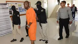 Abdul Rachman Azman asal Tanzania dikawal petugas sebelum konferensi pers di Kantor Pelayanan Bea Cukai Bandara Ngurah Rai, Bali, Selasa (12/2). Abdul menyelundupkan sabu dengan modus menelan 99 butir yang diperkirakan mencapai 1 kg. (Sonny TUMBELAKA/AFP)