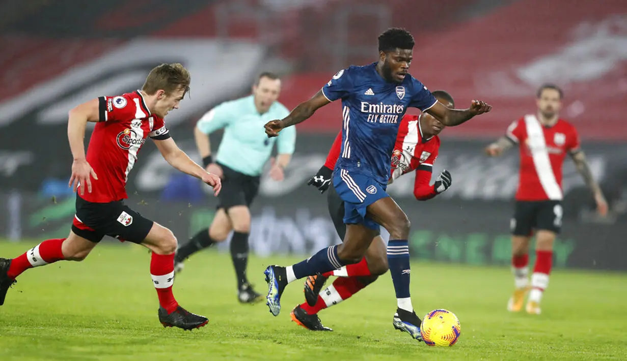 Pemain Arsenal Nicolas Pepe menggiring bola meninggalkan para pemain Southampton pada pertandingan Liga Inggris di Stadion St Mary, Southampton, Inggris, Selasa (26/1/2021). Arsenal menang 3-1 atas Southampton. (AP Photo/Frank Augstein, Pool)