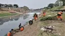 Petugas PPSU dan Sudin Tata Air Jakarta Timur membersihkan sampah dan tanaman liar di sepanjang aliran Kanal Banjir Timur (KBT), Senin (15/10). Aksi dilakukan guna mengantisipasi banjir sekaligus mempercantik kawasan KBT. (Merdeka.com/ Iqbal S. Nugroho)