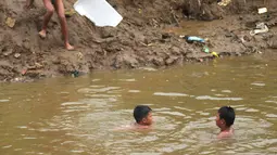Sejumlah anak berenang di aliran Kali Ciliwung, Kampung Pulo, Jakarta, Jumat (2/12/2022).Minimnya lahan bermain menyebabkan anak-anak tersebut bermain tidak pada tempatnya, meskipun dapat membahayakan keselamatan. (merdeka.com/Imam Buhori)