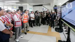 Heru Budi mengenakan kemeja lengan panjang serta celana berwarna krem dan sepatu hitam dengan rompi oranye. Sementara Menhub Budi Karya tampak mengenakan kemeja lengan panjang dan celana jin berwarna biru. (Liputan6.com/Faizal Fanani)