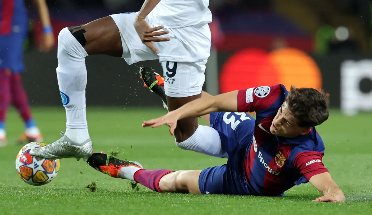 Pemain Barcelona, Pau Cubarsi (kanan) terjatuh saat berebut bola dengan pemain Napoli, Victor Osimhen pada laga leg kedua babak 16 besar Liga Champions 2023/2024 di Estadio Olimpico Lluis Companys, Barcelona, Spanyol, Rabu (13/3/2024) dini hari WIB. Barcelona menang dengan skor 3-1 (agregat 4-2). (AFP/Lluis Gene)