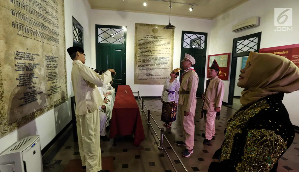 Pengunjung mengenakan kostum adat dan pejuang memerhatikan kutipan pesan kebangsaan di Museum Sumpah Pemuda, Jakarta, Jumat (27/10). Jelang peringatan 89 tahun Sumpah Pemuda, museum ini ramai dikunjungi masyarakat. (Liputan6.com/Faizal Fanani)