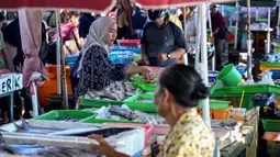 Diketahui, pada 2024, produksi perikanan di Bali didominasi hasil laut dengan total mencapai lebih dari 127 ribu ton, didominasi komoditas tuna dan cakalang. Tampak dalam foto, pedagang menjual ikan di pasar di pantai Kedonganan dekat Denpasar, Bali, pada Jumat 10 April 2026. (SONNY TUMBELAKA/AFP)