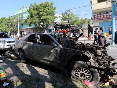 Sejumlah mobil hancur usai ledakan bom dari sebuah mobil di Ibu Kota Mogadishu, Somalia (28/3). Insiden tersebut telah menyebabkan 11 orang tewas dan belasan lainnya terluka. (Reuters/Feisal Omar)