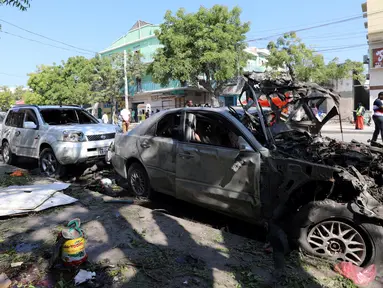 Sejumlah mobil hancur usai ledakan bom dari sebuah mobil di Ibu Kota Mogadishu, Somalia (28/3). Insiden tersebut telah menyebabkan 11 orang tewas dan belasan lainnya terluka. (Reuters/Feisal Omar)