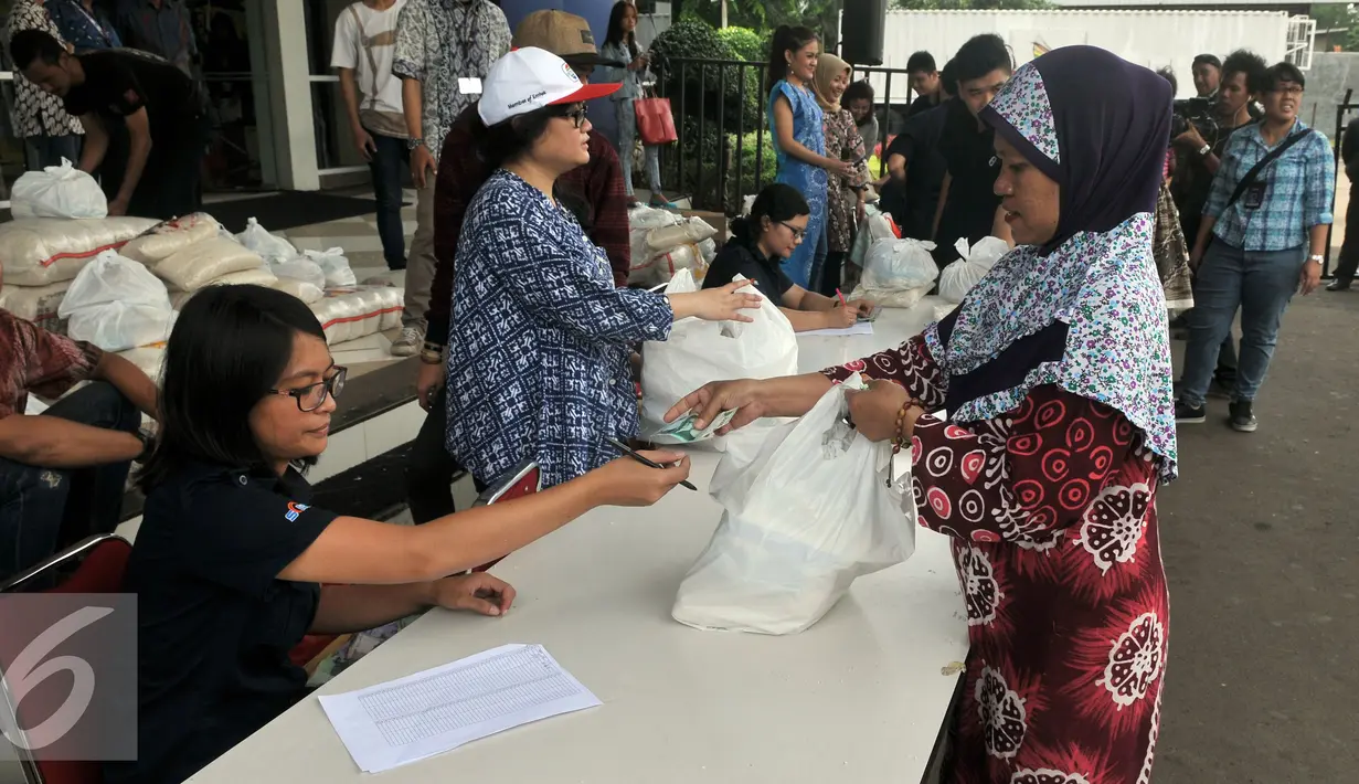 Warga membawa Paket  Sembako Murah oleh PT Indosiar Visual Mandiri  di Studio 5 Indosiar, Jakarta, (10/6). Sebanyak 500 paket sembako murah seharga Rp 30 ribu per paket untuk 500 Kepala Keluarga (KK). (Liputan6.com/Johan Tallo)