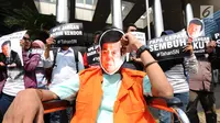 Aktivis Koalisi Masyarakat Sipil Anti Korupsi melakukan aksi teatrikal di depan Gedung KPK, Jakarta, Kamis (14/9). Mereka menuntut KPK segera menahan tersangka kasus dugaan korupsi KTP elektronik, Setya Novanto. (Liputan6.com/Helmi Fithriansyah)