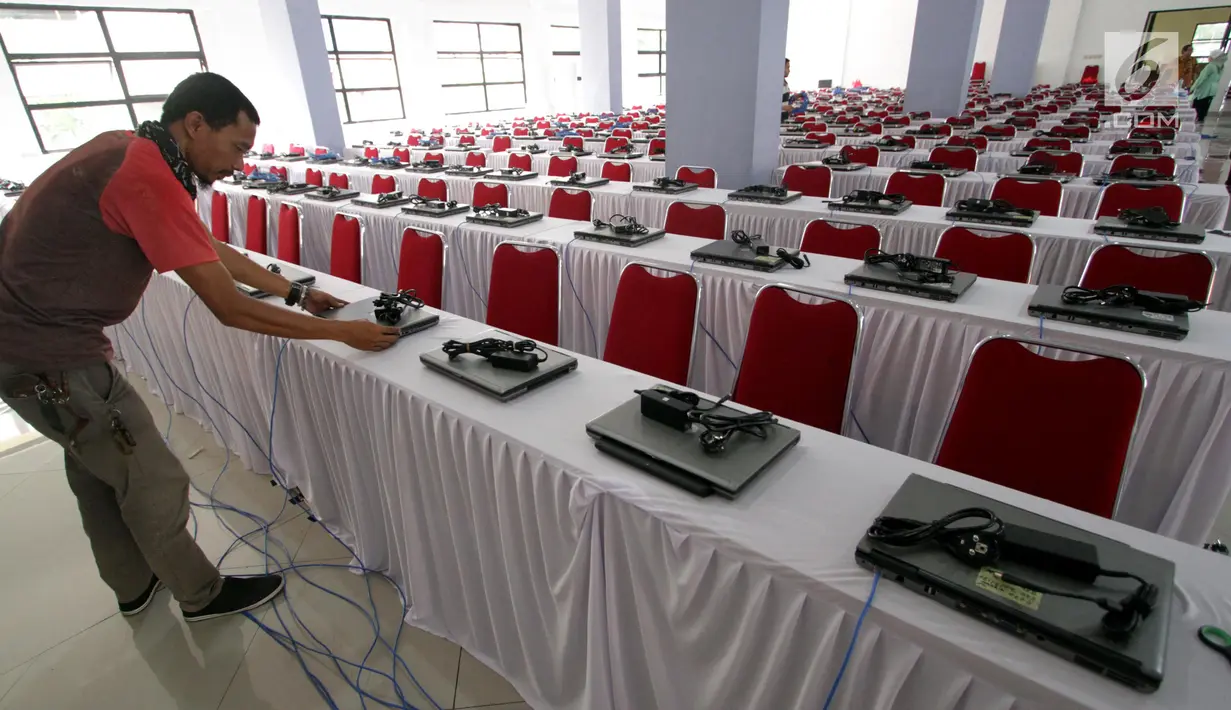 Teknisi menginstal laptop untuk tes calon pegawai negeri sipil (CPNS) di GOR Kelapa Gading, Jakarta Utara, Jumat (26/10). Tempat ini akan menjadi lokasi tes CPNS yang akan dilangsungkan pada Sabtu, 26 Oktober 2018. (Liputan6.com/JohanTallo)
