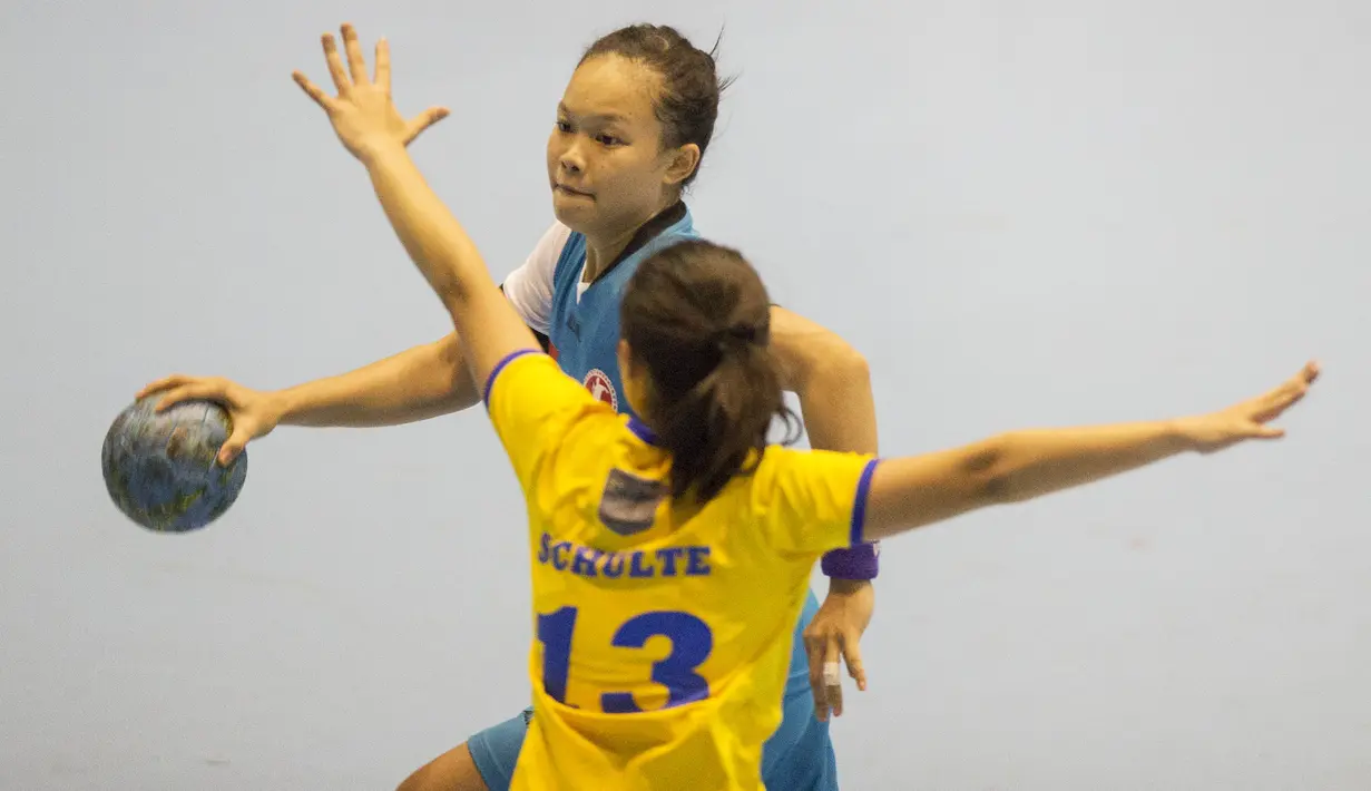 Pebola tangan putri Indonesia, Gadis Risma, berusaha melewati hadangan pebola tangan putri Filipina, Dana Lora Schulte pada International Handball Federation Trophy 2016 di Jakarta, Sabtu (5/3/2016). (Bola.com/Vitalis Yogi Trisna)