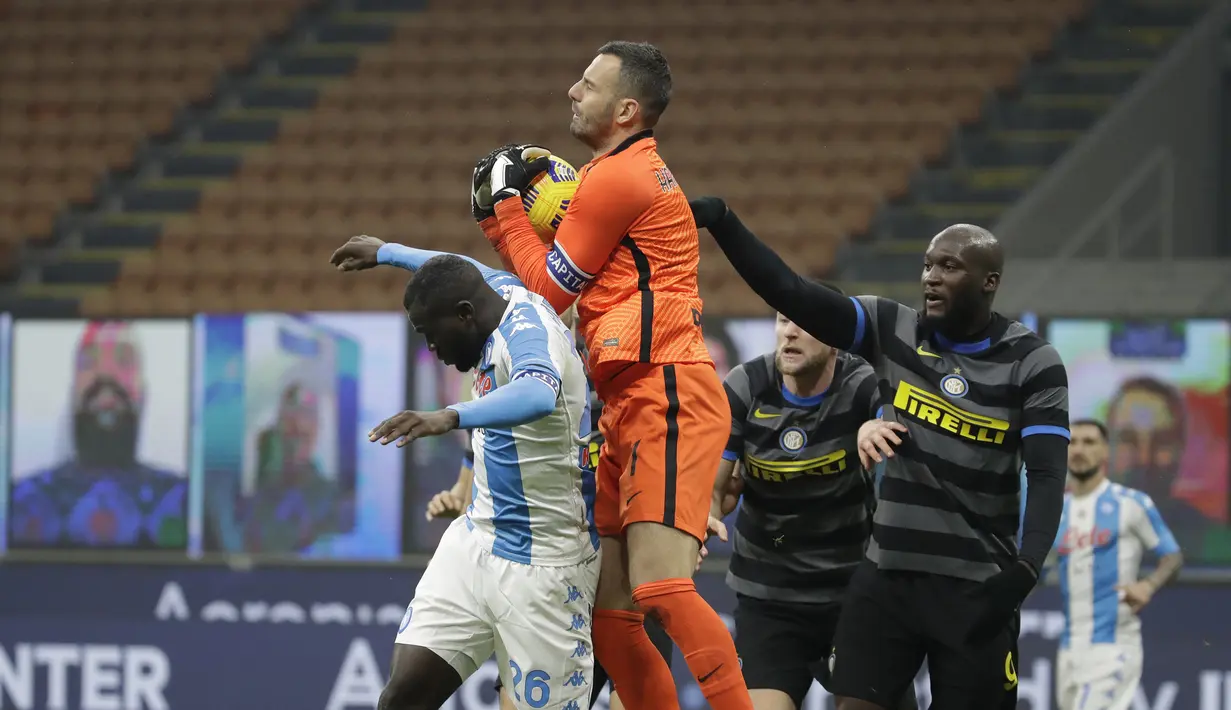 Kiper Inter Milan, Samir Handanovic (tengah), menangkap bola dari ancaman bek Napoli, Kalidou Koulibaly (kiri), dalam laga lanjutan Liga Italia 2020/21 Serie A pekan ke-12 di San Siro Stadium, Rabu (16/12/2020). Inter menang 1-0 atas Napoli. (AP/Luca Bruno)
