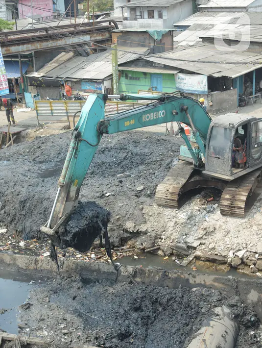 Alat berat mengangkat material endapan lumpur di Kampung Nelayan Cilincing, Jakarta Utara, Kamis (2/9/2021). Pengerukan dilakukan untuk mengurangi pendangkalan di muara teluk Jakarta serta penataan sandaran kapal-kapal tradisional. (merdeka.com/Imam Buhori)