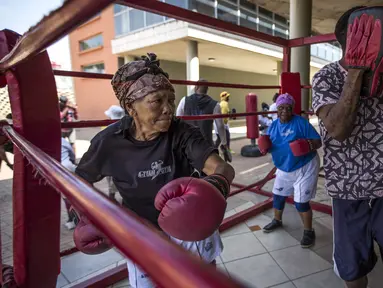 Para nenek berlatih tinju pada Boxing Gogos di Cosmo City, Johannesburg, Selasa (19/9/2017). Berkat latihan rutin yang dipimpin Claude Maphosa ini para lansia berhasil sembuh dari penyakit dan hidup lebih sehat. (AFP/Gulshan Khan) 