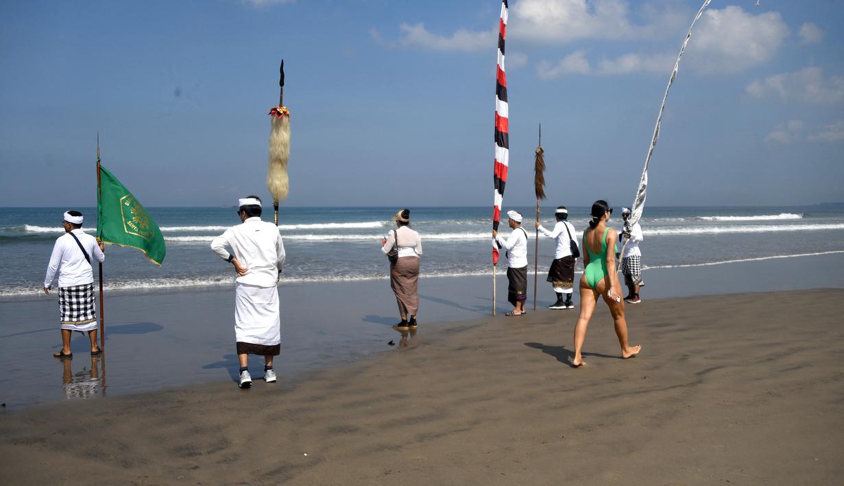 Upacara Melasti dilaksanakan di pinggir pantai dengan tujuan mensucikan diri dari segala perbuatan buruk pada masa lalu dan membuangnya ke laut. Umat Hindu di Indonesia akan memperingati Hari Raya Nyepi Tahun Baru Saka 1945 pada Rabu (22/3/2023) mendatang. (AFP/SONNY TUMBELAKA)