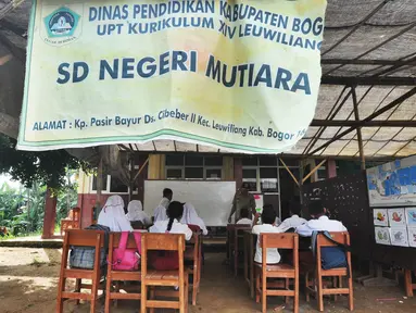 Sejumlah murid Sekolah Dasar Negeri (SDN) Mutiara mengikuti aktivitas belajar di dalam tenda darurat di Kampung Pasir Bayur, Cibeber II, Bogor, Selasa (3/4). Kurang lebih sebulan ini murid kelas 1 hingga 5 belajar di luar kelas. (Merdeka.com/Arie Basuki)