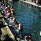 Wisatawan antri membersihkan diri (melukat) di Pura Tirta Empul, Desa Tampaksiring, Gianyar, Bali, jumat (6/5/20222). Dalam sehari, lebih dari 2.000 wisatawan berkunjung ke obyek wisata spiritual i yang menjadi salah satu primadona di Pulau Bali ini. (merdeka.com/Arie Basuki)