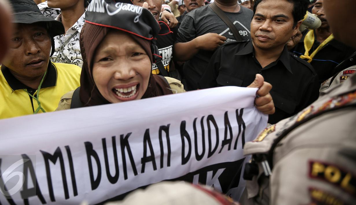 Ekspresi seorang pengunjuk rasa saat menyuarakan orasinya di depan Istana Merdeka, Jakarta, Rabu (10/2). Guru honorer dari seluruh Indonesia itu menuntut Pemerintah agar mengangkat mereka sebagai PNS (Liputan6.com/Faizal Fanani)