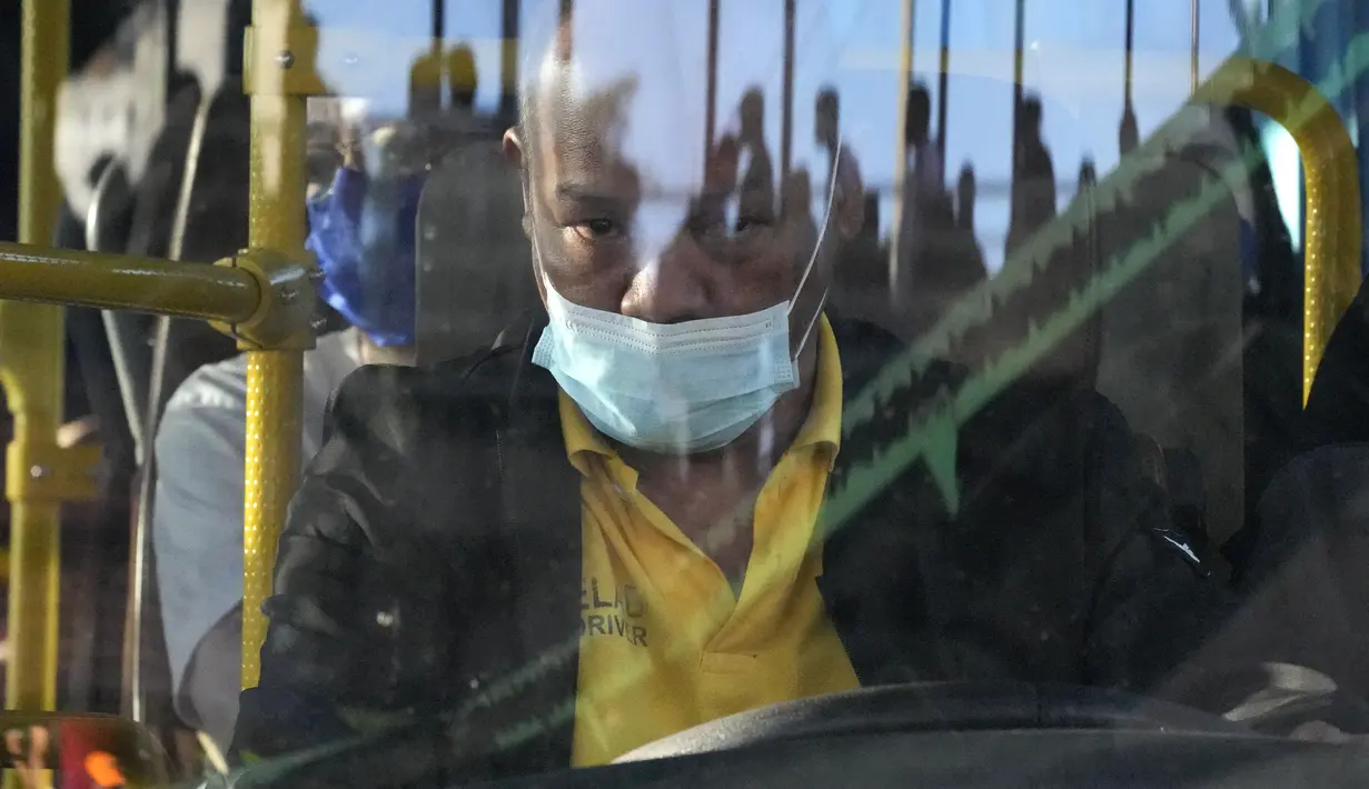 Seorang sopir bus yang mengenakan masker berhenti untuk mengangkut penumpang di Manila, Filipina, Kamis (8/9/2022). Presiden Filipina Ferdinand Marcos Jr. telah menyetujui rekomendasi untuk mengakhiri wajib memakai masker di luar ruangan di seluruh negeri. (AP Photo/Aaron Favila)