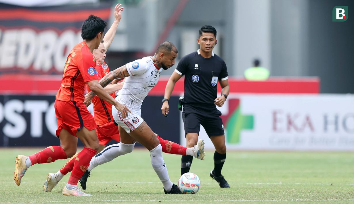 <p>Pemain Arema FC, Gustavo Almeida Dos Santos (tengah),&nbsp;berusaha melewati hadangan&nbsp;pemain&nbsp;Persija Jakarta, Maciej Gajos dalam pertandingan pekan kesembilan BRI Liga 1 2023/2024 yang berlangsung di Stadion Patriot Candra Bhaga, Bekasi, Minggu (20/9/2023). (Bola.com/M Iqbal Ichsan)</p>