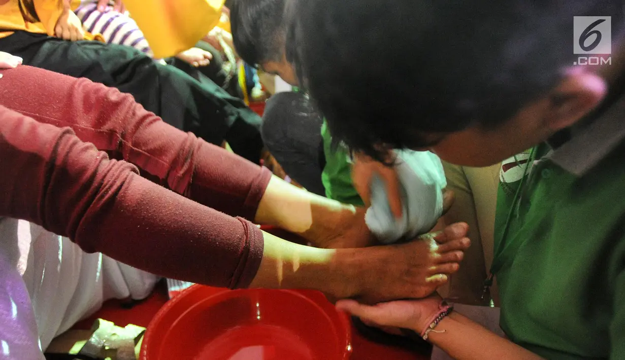 Seorang narapidana anak membasuh kaki ibunya di Lembaga Pembinaan Khusus Anak (LPKA) Kelas 1 Tangerang, Banten (17/4). Kegiatan ini dilakukan serentak di seluruh LPKA di Indonesia. (Merdeka.com/Arie Basuki)