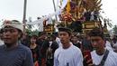 Ribuan warga mengiringi arak-arakan Bade atau menara bertingkat sembilan yang berisi jenazah anggota keluarga dari pahlawan nasional I Gusti Ngurah Rai dalam prosesi upacara Ngaben di Desa Carangsari, Badung, Bali, Senin (29/4/2019). (SONNY TUMBELAKA/AFP)