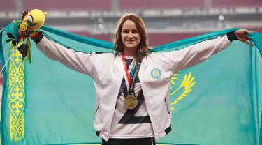 Atlet lompat tinggi Kazakhstan, Nadezhda Dubovitskaya mengibarkan bendera di podium setelah berhasil meraih perunggu di Asian Games 2018 di Jakarta, Kamis (30/8). (AP Photo/Bernat Armangue)