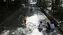 Anak-anak bermain bisbol di jalan setapak menuju kuil Shinto Hikawa-Jijja shinto, Tokyo, Jepang, 19 April 2020. Daya tarik liburan menguji persatuan masyarakat dalam menghadapi virus corona COVID-19. (AP Photo/Kiichiro Sato, File)
