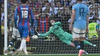 Kiper Crystal Palace, Dean Henderson menghalau bola tendangan penalti pemain Manchester City, Omar Marmoush dalam laga final Piala FA 2024/2025 di Stadion Wembley, London, Inggris, Sabtu (17/05/2025) waktu setempat. (AFP/Adrian Dennis)