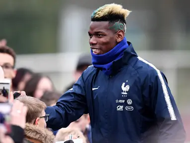 Gelandang timnas Prancis Paul Pogba menyapa penggemar sebelum mengikuti sesi latihan di Clairefontaine-en-Yvelines, Paris (19/3). Pogba bersama timnas Prancis melakukan latihan jelang pertandingan persahabatan. (AFP Photo/Franck Fife)