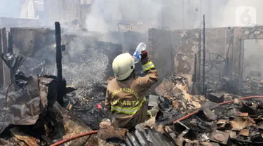 Petugas pemadam kebakaran meminum air saat berusaha menjinakkan api yang melahap permukiman warga di Jalan Kebon Jeruk 13, Taman Sari, Jakarta Barat, Minggu (6/10/2019). Kebakaran menghanguskan puluhan rumah di dua kelurahan, Taman Sari dan Mapar. (merdeka.com/Iqbal Nugroho)