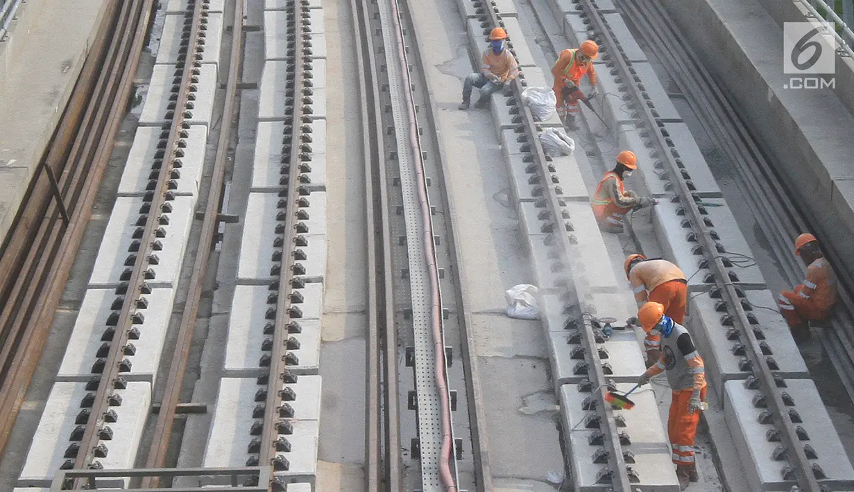 Pekerja menyelesaikan Rel Light Rail Transit (LRT) di Jakarta, Selasa (26/2). Light Rail Transit (LRT) Jabobek trase Cawang–Cibubur bakal diujicoba pada pertengahan tahun ini. (Liputan6.com/Herman Zakharia)