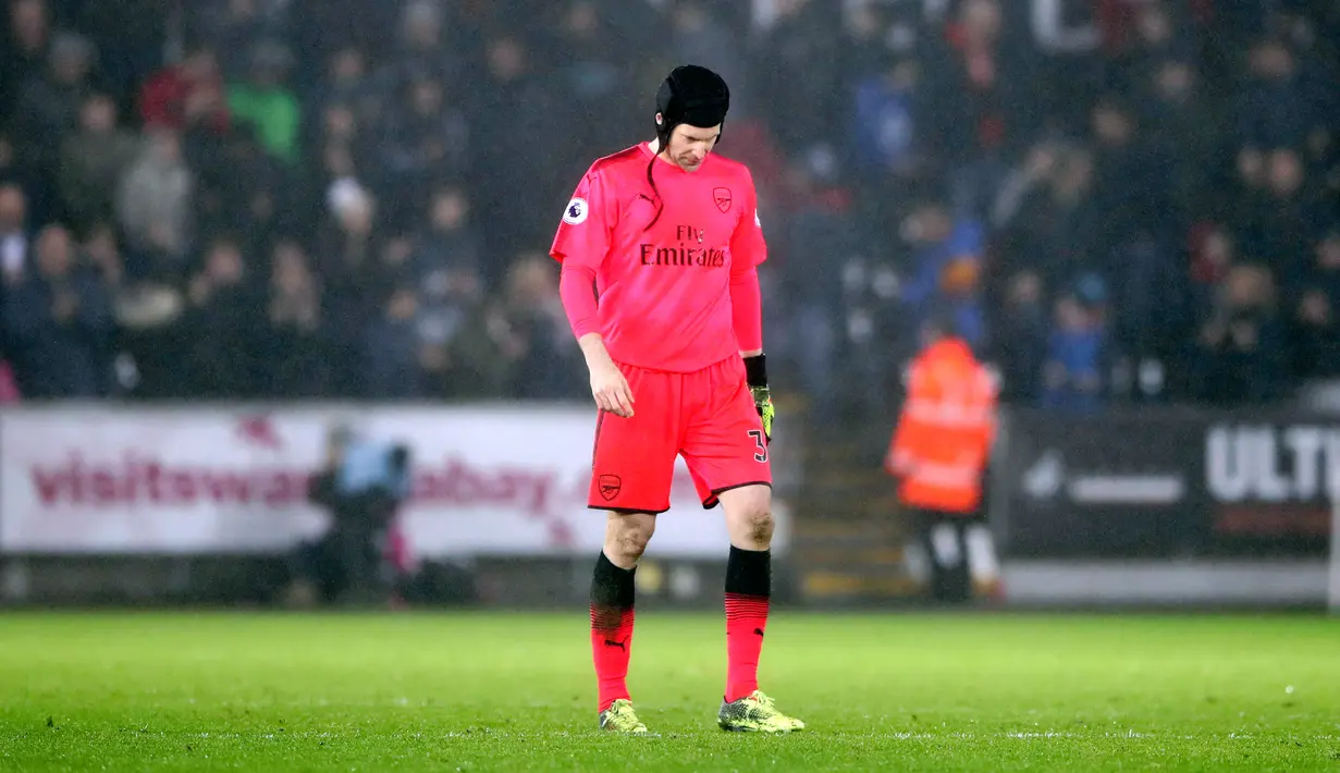 Kiper Arsenal, Petr Cech tertunduk lesu setelah dikalahkan Swansea City dalam laga pekan ke-25 Premier League di Liberty Stadium, Selasa (30/1). Sempat unggul, pemain Swansea memaksa Arsenal tiga kali melihat gawang mereka kebobolan (Nick Potts/PA via AP)