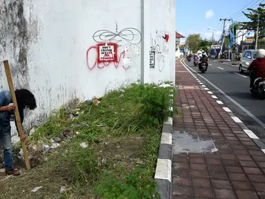 Seorang jurnalis memeriksa lubang yang digunakan narapidana asing untuk kabur dari Lapas Kerobokan, Bali, Senin (19/6). Empat narapidana asing kabur masih diburu petugas setelah meloloskan diri dari lapas melalui terowongan tersebut. (SONNY TUMBELAKA/AFP)