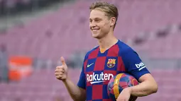 Gelandang baru Barcelona, Frenkie de Jong tersenyum saat berpose setelah pengenalan dirinya  di stadion Camp Nou, Spanyol (5/7/2019). Frenkie de Jong resmi diperkenalkan Barcelona sebagai bagian terbaru skuat mereka untuk musim 2019-2020. (AFP Photo/Lluis Gene)