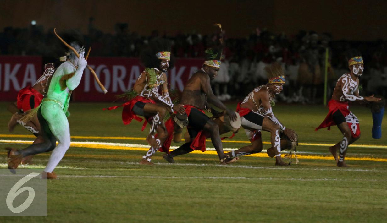 Penari menampilkan tarian khas daerah saat pembukaan Torabika Soccer Championship presented by IM3 Ooredoo di Stadion Mandala Jayapura, Papua, Jumat (29/4/2016). Laga perdanamempertemukan Persipura vs Persija. (Liputan6.com/Helmi Fithriansyah)