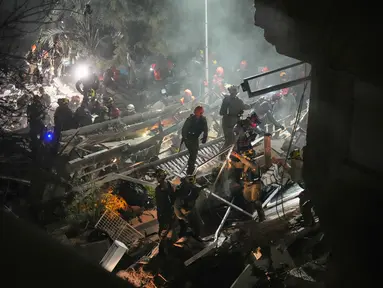 Pasukan keamanan Israel dan tim penyelamat melakukan upaya pencarian korban di tengah reruntuhan bangunan tempat tinggal yang dihantam rudal Iran di Haifa, Israel, Minggu, 5 April 2026. Rudal Iran menghantam sebuah bangunan tempat tinggal di Kota Haifa, Israel. (AP Photo/Ariel Schalit)