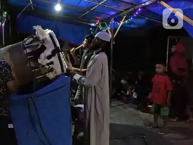 Sejumlah warga memukul bedug pada malam takbiran di kawasan Tanah Baru, Bogor, Jawa Barat, Sabtu (23/5/2020). Di tengah pandemi virus corona COVID-19, sejumlah warga tetap merayakan malam takbiran dengan memukul bedug. (Liputan6.com/Herman Zakharia)