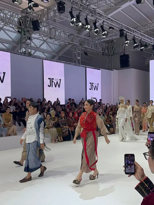 Nagita Slavina melenggang bak model di atas panggung JFW 2024, hari Rabu (25/10/2023) mengenakan outfit rancangan Surya Abduh. Nagita Slavina cantik mengenakan wastra, yaitu kain Ulos bernuansa cokelat dengan detail manis berupa lengan serut dan outer merah seperti vest. [Foto: Instagram/uwiemariska]