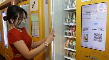 Pengunjung membeli minuman dengan QRIS pada Smart Vending Machine di East Mall Grand Indonesia, Jakarta, Selasa (24/05/2022). Blibli dan Jumpstart berkolaborasi meluncurkan vending machine pertama di Indonesia yang menawarkan ragam produk UMKM terbaik binaan Blibli di bawah GDP Ventures. (Liputan6.com/Fery Pradolo)