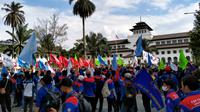 Para buruh menggelar aksi unjuk rasa menolak penetapan upah minimum dengan formula PP 36 Tahun 2021 di depan Gedung Sate, Kota Bandung, Kamis (25/11/2021). (Foto: Liputan6.com/Huyogo Simbolon)